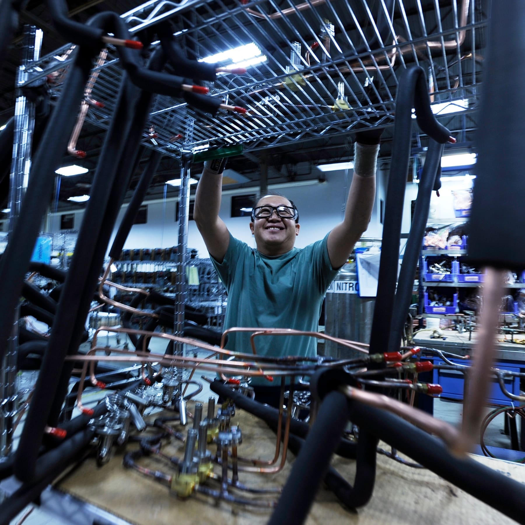 man building commercial kitchen equipment on the factory floor