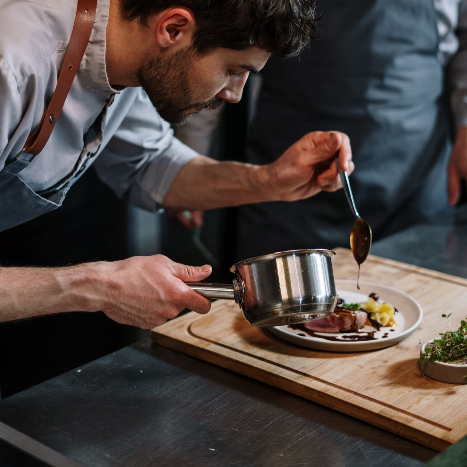 man preparing a cooked entre at restaurant