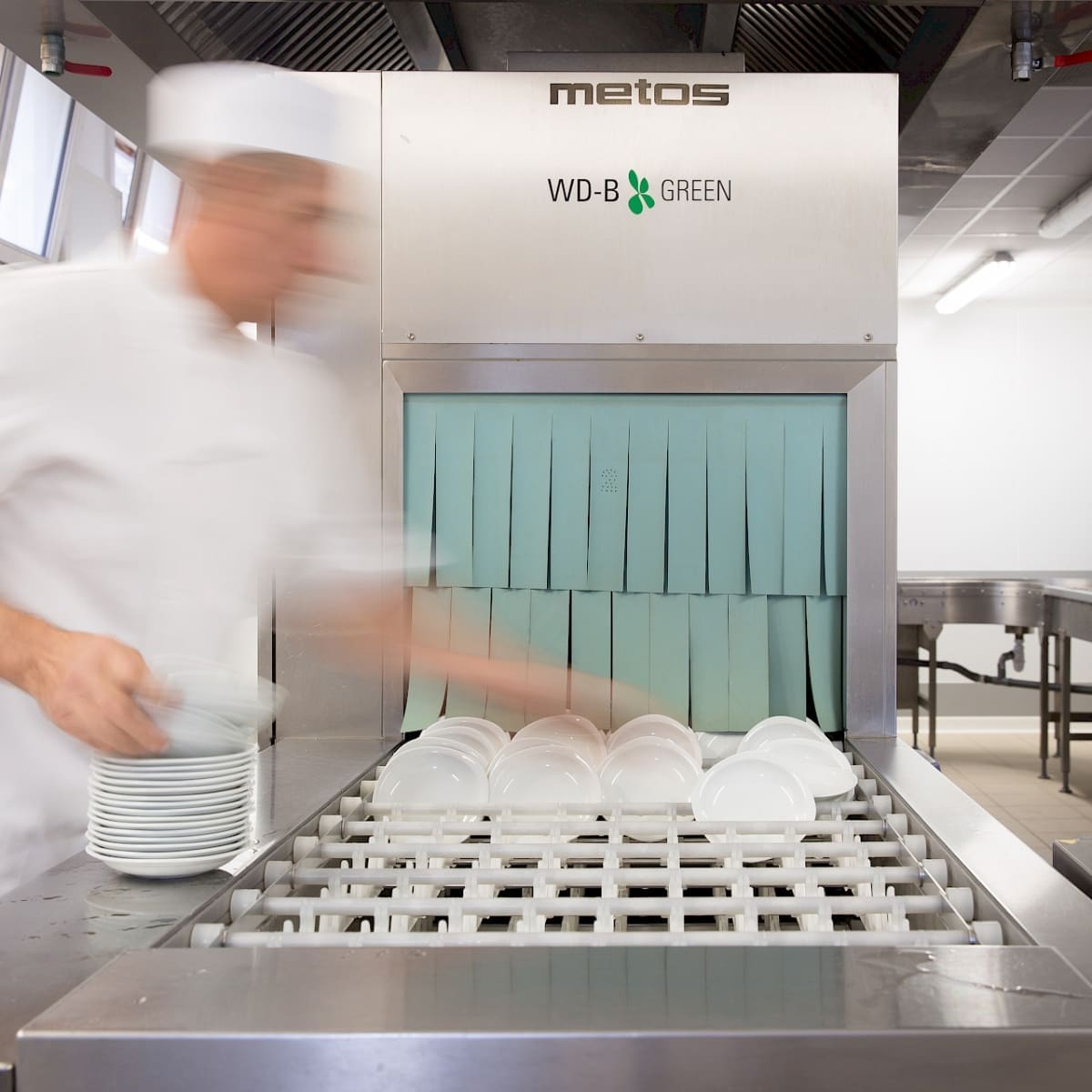 man washing dishes in a restaurant kitchen